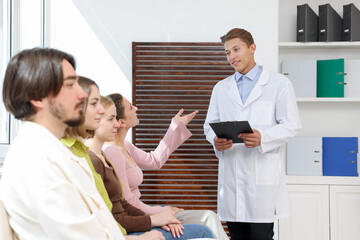 Fototapeta premium People waiting in queue on chairs at hospital