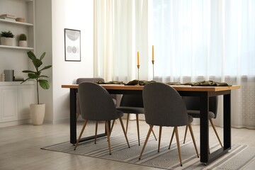 Decorated wooden table with chairs in dining room