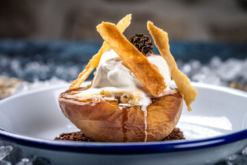 Baked peach with ice cream and crispy wafers.