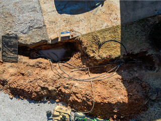 Aerial top down of tractor digging up septic tank in winter in driveway in winter