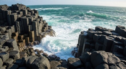 Dark basalt columns form a dramatic coastal scene. Ocean waves crash against jagged rock formations