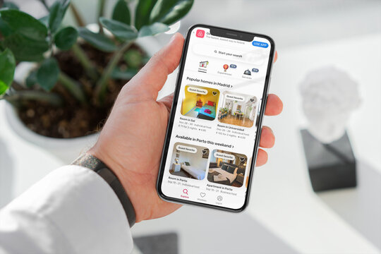 Businessman using airbnb app on smartphone for booking accommodation
