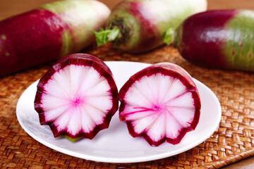 Fresh Watermelon Radish Slices Showing Pink Starburst Pattern on Wooden Display