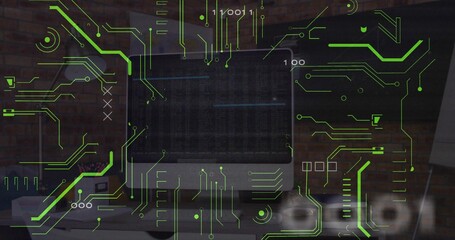 Showing flat-screen monitor with code, neon circuit graphics and binary digits on office desk