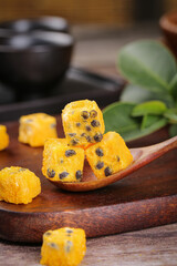 Freeze dried passion fruit cubes on wooden spoon - instant tea ingredient and healthy snack