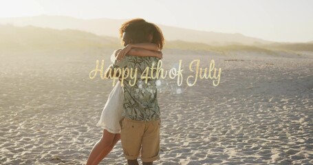 Embracing couple wearing tropical shirt and dress on sunset beach with Happy 4th of July overlay
