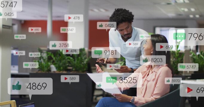 Reviewing colleagues discussing social media metrics in corporate lounge, with tablet and reports