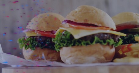 Displaying three mini cheeseburgers sitting on wooden tabletop with french fries and glitch effects