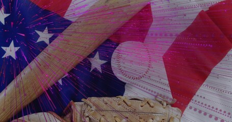 Displaying wooden bat and glove holding baseball on US flag in studio, magenta fireworks overlay