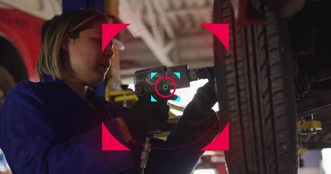 Removing lug nuts coverall-clad mechanic using air impact wrench on tire in service bay, copy space - Powered by Adobe