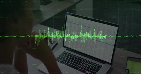Woman in long-sleeve top reviewing spreadsheet at desk with laptop tablet green waveform overlay
