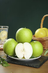 Fresh Green Apples on Plate with Sliced Half Showing White Flesh and Natural Kitchen Setting