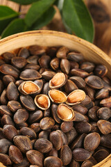 Fototapeta premium Fresh Wild Pine Nuts Harvested from Deep Forest in Wooden Basket with Natural Shells and Seeds