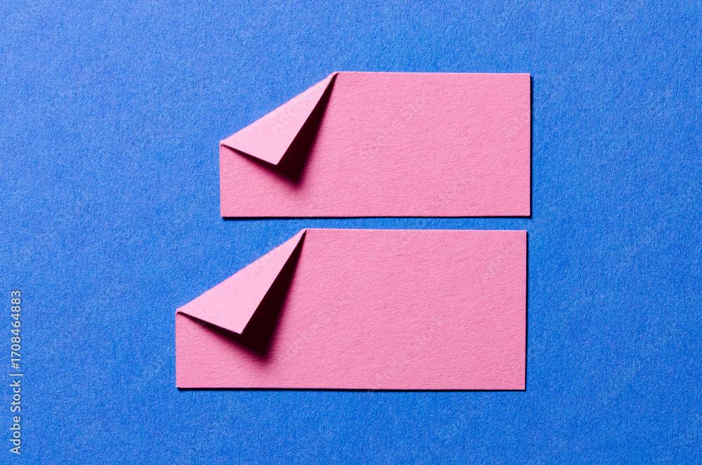 Poster pink paper message notes or sheets with folded edge dog-ear earmark and copy space for text on blue 