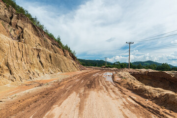 Landscape of dirt road in countryside with blue sky. Road in rainy season. Side view of dirt road on top mountain. road background.