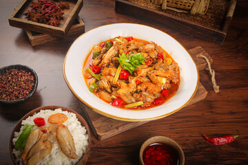 Spicy Stir-Fried Bullfrog Hot Pot Chinese Cuisine with Rice and Traditional Spices on Wooden Table