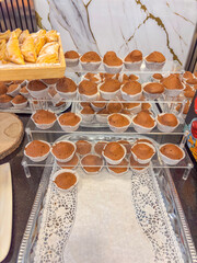 rows of chocolate cupcakes on a tiered display at a buffet table, a concept of all inclusive, hotel breakfast and food service