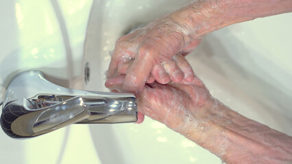 The concept of protecting the body from germs and viruses. Close up hands of senior man that applying lather and soap to make cleaning from germ, bacteria. Protect yourself from infection