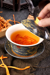 Chinese Traditional Herbal Medicine Tea with Golden Cordyceps and Healing Herbs in Decorative Dragon Teacup