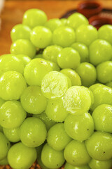 Fresh Green Seedless Grapes with Water Droplets in Natural Sunshine Light
