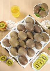 Fresh Shaanxi Golden Kiwifruit Display in Wooden Box with Sliced Fruit and Yellow Heart Bowl on Wood Table
