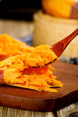 Sweet Potato Mash with Honey on Wooden Spoon - Fresh Cooked Orange Potatoes