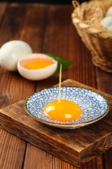 Fresh Egg Yolk in Decorative Bowl on Wooden Board - Culinary Cooking Ingredient