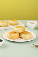 Traditional Golden Puff Pastry Mooncakes with Tea for Mid-Autumn Festival Celebration