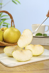Fresh Pear Slices on White Cutting Board with Whole Pears in Basket Kitchen Food Photography