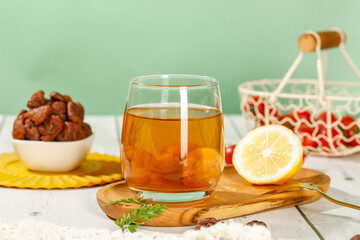 Herbal tea with lemon and nuts on rustic wooden table - healthy drink concept