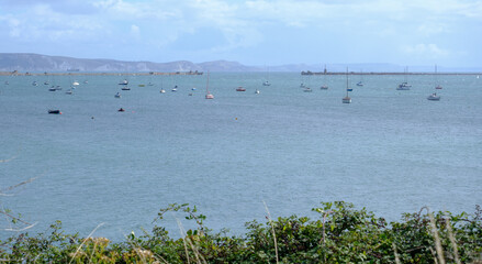 Portland Harbour entrance, showing the entrance to the historic harbour near Weymouth with moored sail boats.