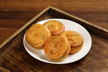 Traditional Golden Mooncakes with Decorative Patterns on Wooden Tray - Chinese Mid-Autumn Festival Pastry