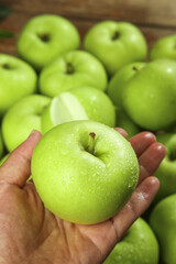 Fresh Green Apple with Water Drops in Hands - Premium Quality Fruit Showcase