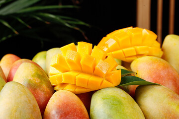 Fresh Ripe Mango Fruit Diced and Whole with Tropical Leaves Organic Produce Display