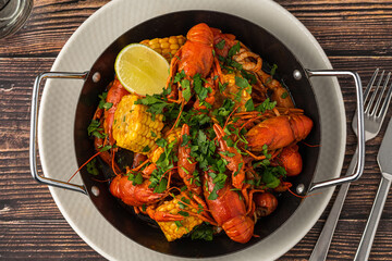 Cooked crayfish with corn and herbs in a serving pan