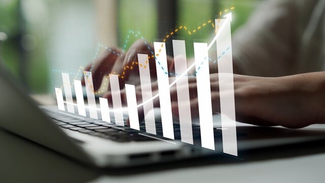 A close-up view of hands typing on a laptop with data visualization overlay depicting growth trends, perfect for business and financial contexts in modern workplaces. Copula - Powered by Adobe