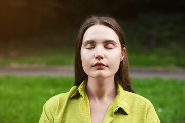Woman meditating to heal or restore her aura in nature