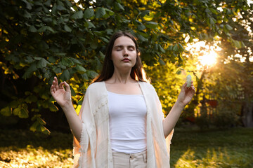 Woman meditating with crystal to heal or restore her aura outdoors