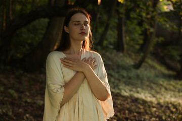 Woman meditating to heal or restore her aura in nature