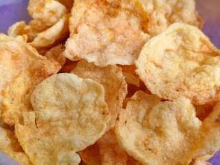 Close-up of crispy fried melinjo chips with a golden brown texture and crunchy appearance.