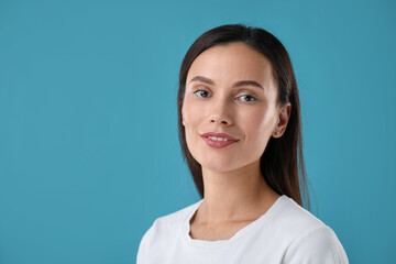 Portrait of beautiful woman on blue background. Space for text