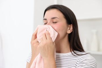 Young woman with clean laundry at home