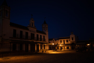 Fototapeta premium El Rocio, Sevilla, Andalusia, Spain. 28 August 2025. Hermandad house illuminated at dusk