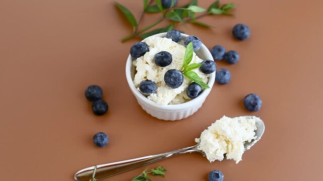 White dessert cottage cheese with blueberries and mint on the table