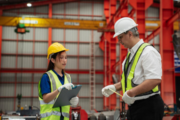 Industrial workers in safety helmets and vests measuring metal sheets inside a modern factory, ensuring quality control, teamwork, and precision in steel manufacturing process.