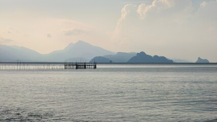 A scenic view of a body of water with mountains in the background and a small wooden pier