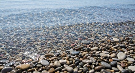 Clear water washes over a beach of colorful pebbles
