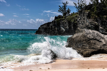 Serene Jobson's Cove, Bermuda: Crystal-Clear Turquoise Waters, Sandy Shore, and Rocky outcrops Under a Bright Blue Sky with Scattered Clouds