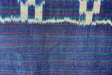 Handwoven ikat textile featuring colorful geometric patterns. Perfect for backgrounds, fashion, interior design, and cultural themes.