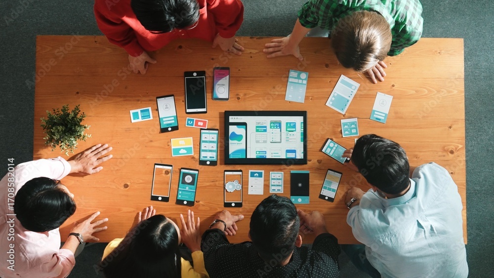 Poster top view of software developer team looking ux ui design for mobile phone interface from tablet whil